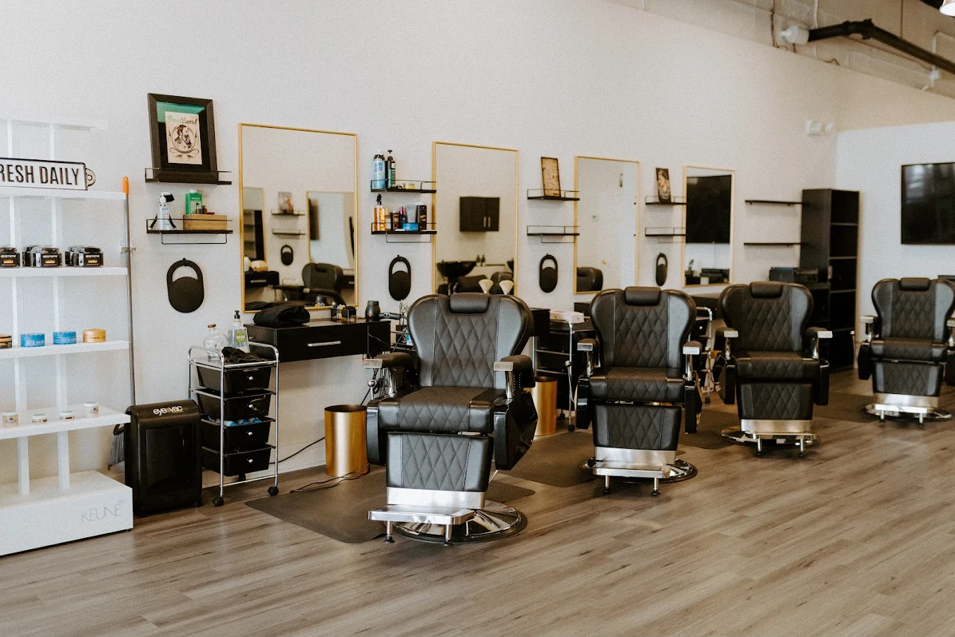 Inside Victory Barbershop — barber chairs, gold-framed art and vintage photographs in Boca Raton